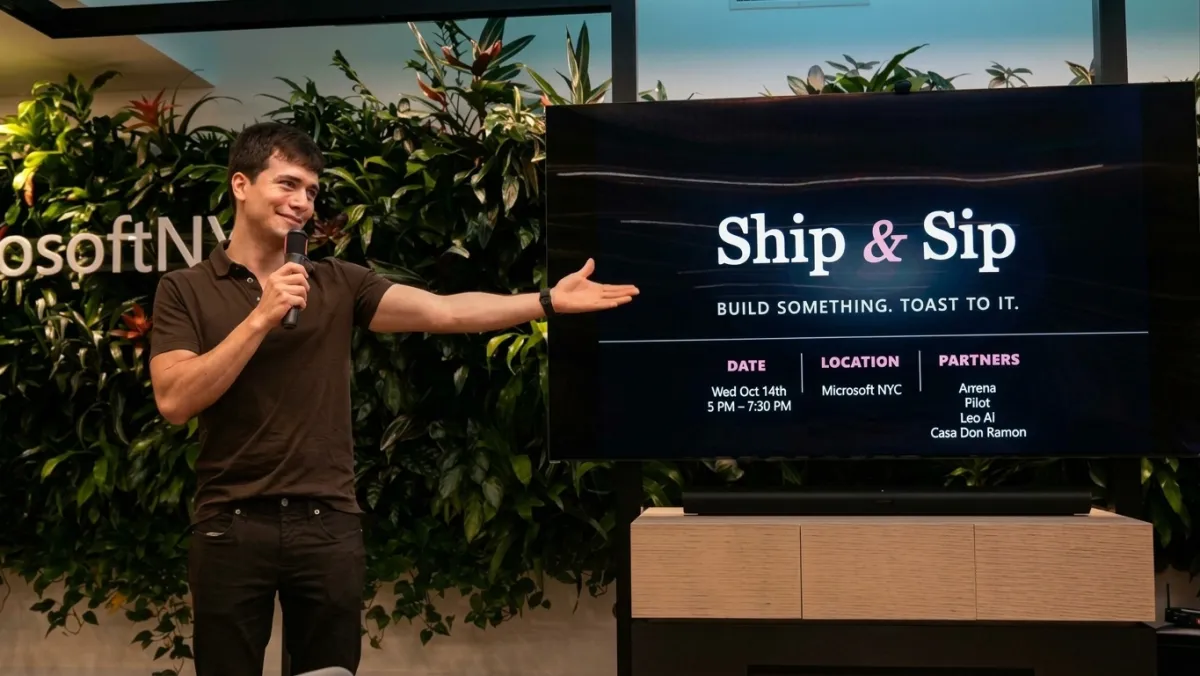 Host Miguel Martinez on stage next to the event screen