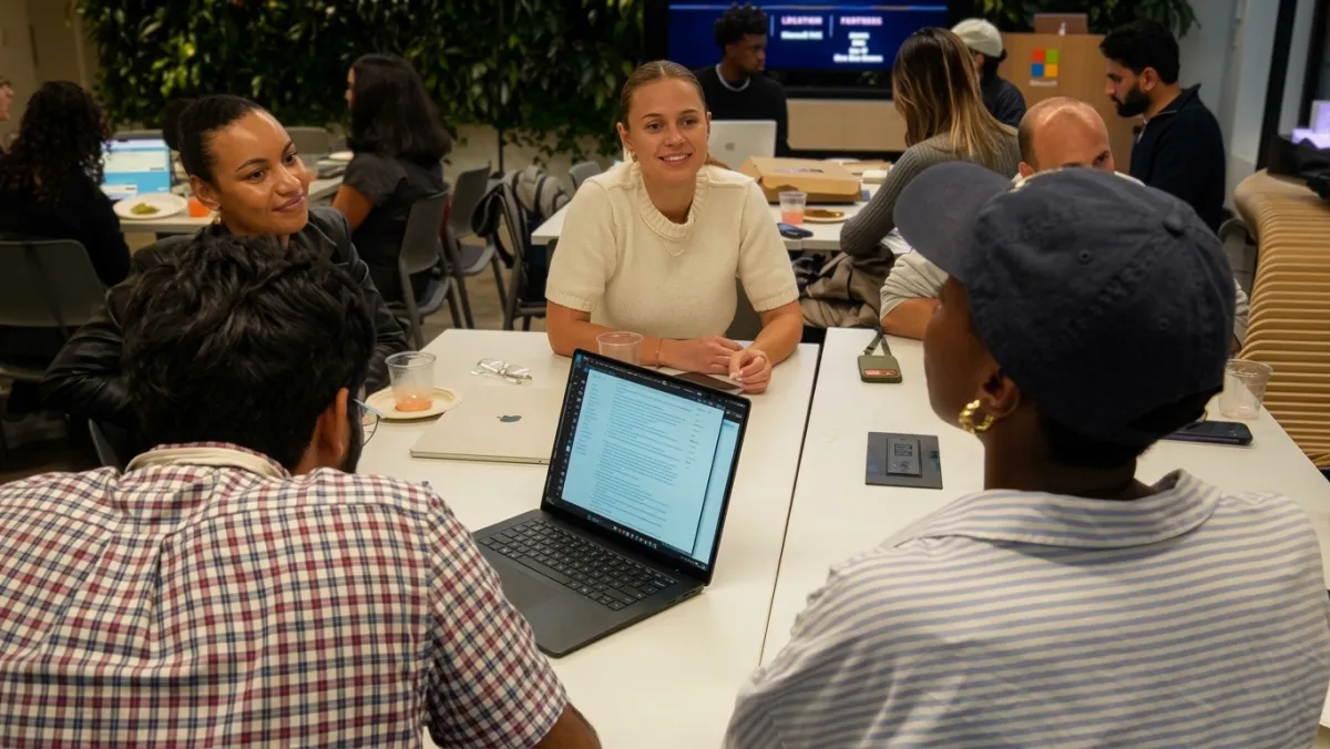 Builders around a table with laptops